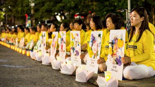 I praticanti del Falun Gong organizzano una veglia a lume di candela davanti al Consolato cinese di Toronto il 13 luglio 2019, tenendo in mano le foto dei praticanti morti a causa delle persecuzioni in Cina.